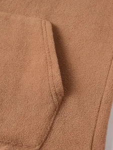 Detailed macro view showing the brown fleece fabric and stitching of the sweatshirt