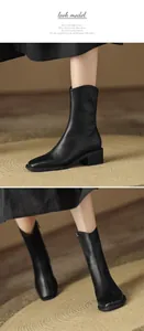 Detailopname van elegante zwarte zachte lederen halfhoge laarzen met vierkante neus