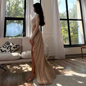 Élégant ensemble beige deux pièces avec haut ajouré et jupe longue à fente latérale.