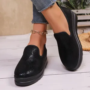 Detail view of black textured slip-on loafers with thick platform soles for women