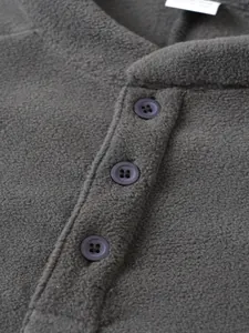 Close-up view of a dark grey fleece sweatshirt featuring three buttons on the collar