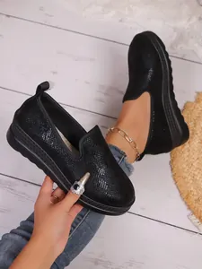 Close-up of black textured slip-on loafers with thick soles and stylish round toe design