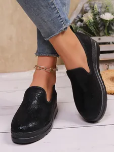 Close-up of black textured slip-on shoes with platform sole and round toe for women