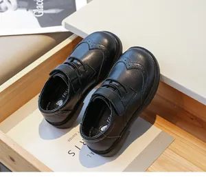 Detail view of boys black formal leather shoes with classic British brogue carving