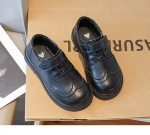 Side view of boy's black Oxford shoes with Velcro straps and wingtip detail