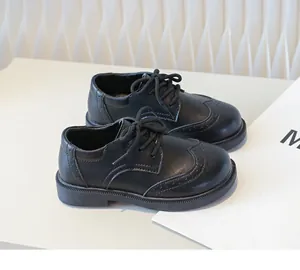 Detailed view of boys' black leather brogue shoes with classic lace-up design