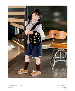 Vue en pied d'un enfant mannequin portant des chaussures en cuir marron rétro stylées