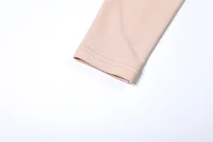 Vue rapprochée du poignet à double couture d'un t-shirt à manches longues rose pêche et ajusté