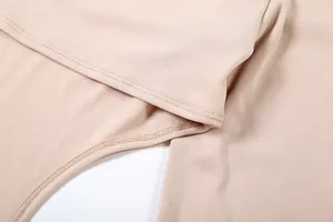 Détail en gros plan des coutures et de la texture douce du tissu d'un haut beige asymétrique