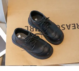 Classic black children's Oxford leather shoes featuring elegant brogue detailing and soft soles