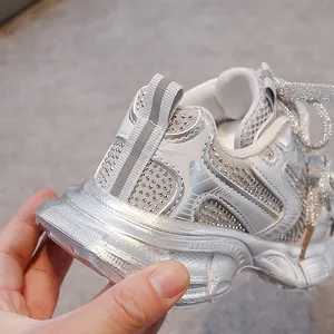Close-up detail of silver children's dad shoes with sparkling rhinestone embellishments.