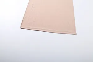 Gros plan montrant les coutures de qualité et le tissu lisse de l'ourlet de cette jupe beige