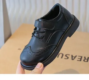 Close-up detail of boys' black leather brogue shoes with soft sole and velcro strap