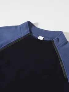 Detailansicht einer blau-schwarzen Fleecejacke für Herren mit Stehkragen und Reißverschlüssen.
