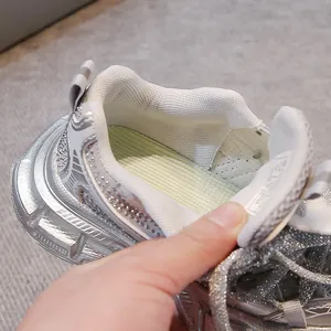 Close-up of silver rhinestone sneaker showing breathable mesh lining and cushioned insole.