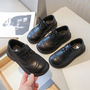 Boys black leather dress shoes with brogue detailing and soft sole for school performance.