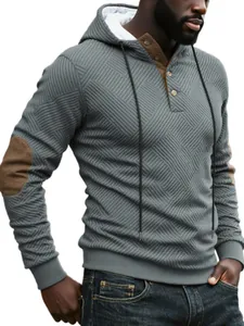 Detailed view of grey textured heavyweight hoodie with brown elbow patches and buttoned collar