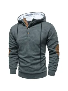 Detail of men's textured hooded sweatshirt with button placket and elbow patches