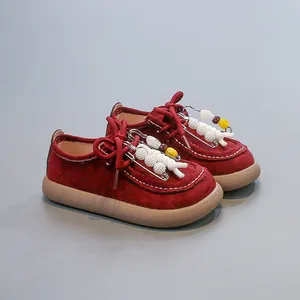 Vue détaillée de chaussures en cuir bordeaux pour enfants avec épingles décoratives