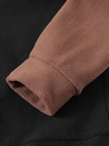 Makro-Detail des weichen Korallenvlies-Ärmelbündchens an einem Herren-Winterpullover.