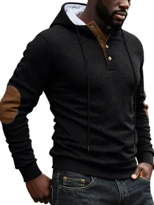 Detail of men's heavy black textured hoodie with brown elbow patches and buttoned collar.