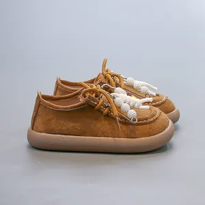 Vue détaillée de chaussures en daim marron pour enfants avec breloques astronaute