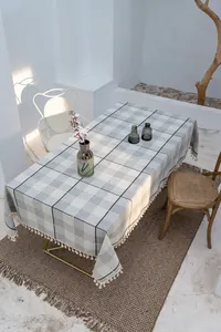 Detail einer grau karierten Tischdecke aus Baumwollleinen mit eleganten Fransen