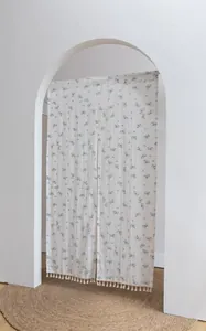 Elegant floral cotton door curtain with tassels displayed in a minimalist white archway