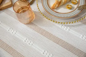Close-up detail showing the intricate hollow-out and embroidered texture of the white tablecloth