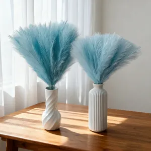 Elegant blue artificial pampas grass in white ceramic vases for wedding home decor