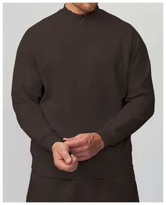 Dettaglio di felpa sportiva da uomo marrone scuro con colletto rialzato e chiusura lampo.