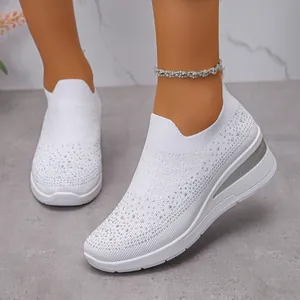 Dettaglio di sneaker bianche in fly-woven con strass scintillanti e suola a zeppa