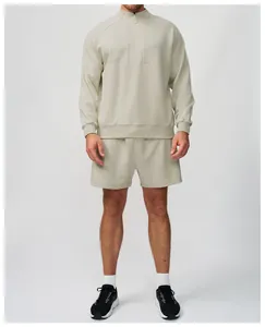 Vista frontale set sportivo uomo beige con felpa con zip e pantaloncini abbinati per outdoor