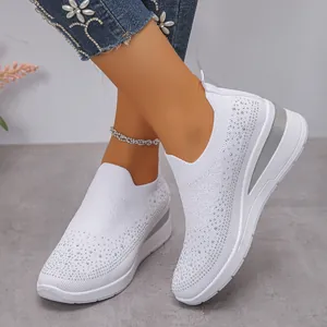 Dettaglio di sneaker con zeppa in flyknit con strass bianchi da donna indossate