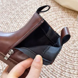 Gedetailleerde close-up van bruine platform Chelsea boots met ritssluiting en zachte voering.