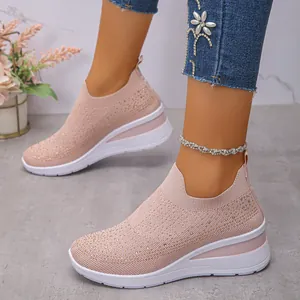Dettaglio delle sneakers in maglia rosa con strass e suola platform bianca su modella