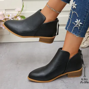 Detalle de botines de cuero sintético negro con tacón de 3,7 cm y cremallera trasera