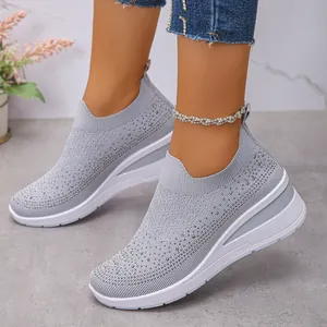 Vista dettagliata delle sneaker grigie in fly-knit con strass e zeppa bianca