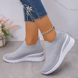 Vista dettagliata degli abbellimenti in strass sulle sneaker in maglia grigia platform.