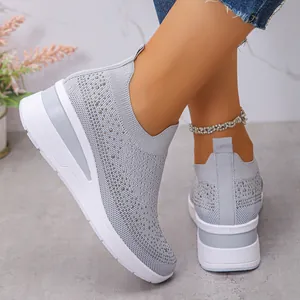 Dettaglio ravvicinato di sneaker grigie in tessuto con strass scintillanti e suola spessa