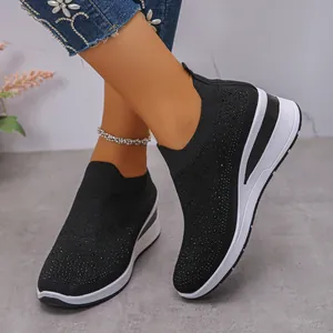 Dettaglio delle sneakers nere da donna in tessuto fly-woven con strass e zeppa bianca