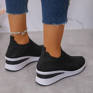 Primo piano di sneaker nere in maglia con strass e spessa suola platform bianca