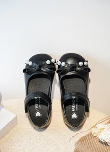 Vue détaillée des chaussures de princesse noires pour filles avec nœud en perles élégant.