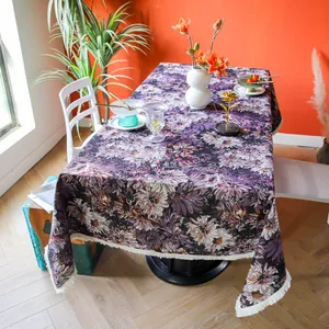Thick purple floral tablecloth with white fringe shown in an elegant dining setting