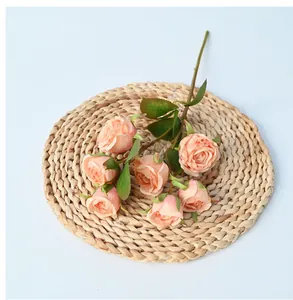 Detailed view of apricot silk roses on a woven mat for elegant home decoration
