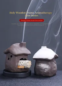 Detailed view of ceramic cottage incense burners with smoke rising from chimneys.