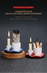 Detailed view of red and blue ceramic incense holders with lit candles and white sage