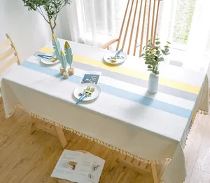 Detailansicht einer modernen Tischdecke mit gelben und blauen Streifen und Quasten.