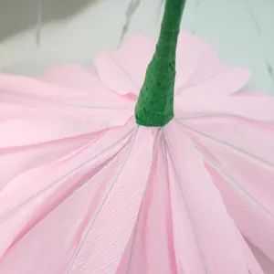 Detailed close-up showing the assembly of pink crepe paper poppy petals on green stem