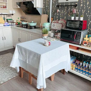 Close-up of white French lace tablecloth with embroidered patterns in kitchen setting